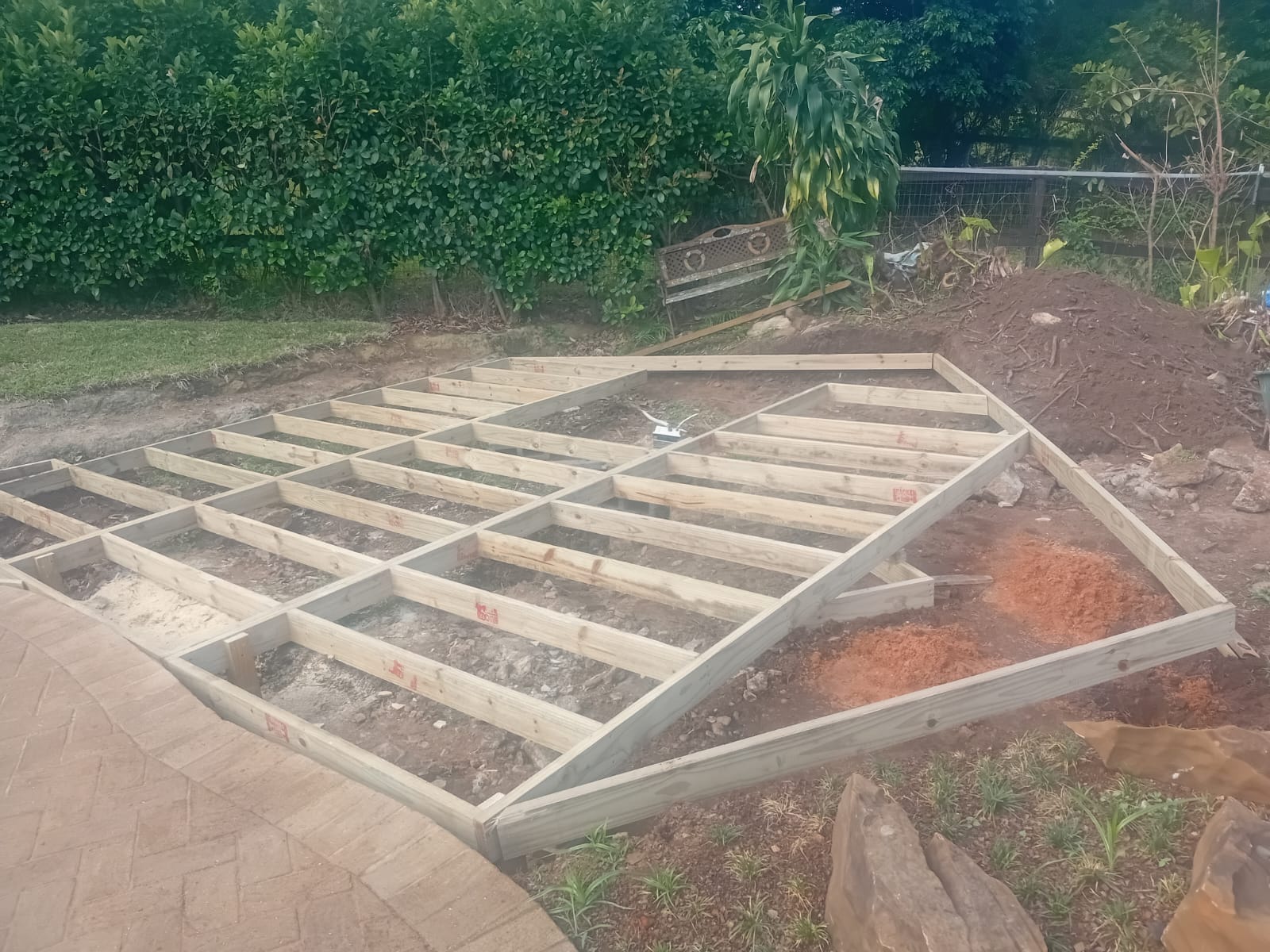 Wide view of the pine deck framework taking shape around the curved pool paving at Kirtlington, Hillcrest.
